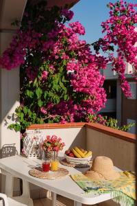 une table avec des assiettes de nourriture et des fleurs roses dans l'établissement I Cinque Pini, à Follonica