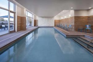 a swimming pool with blue water in a building at Homewood Suites by Hilton Boston Woburn in Woburn