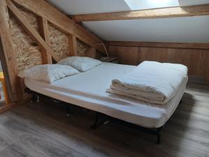 a bed with white sheets and pillows in a room at Loue appartement duplex de 90m2 refait à neuf in Villefort