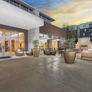 un edificio con un patio con mesas y sillas en DoubleTree by Hilton San Antonio Northwest - La Cantera, en San Antonio