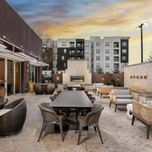 un patio con mesas, sillas y edificios en DoubleTree by Hilton San Antonio Northwest - La Cantera en San Antonio