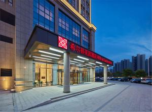 a building with a sign on the front of it at Hilton Garden Inn Xuzhou Yunlong in Xuzhou