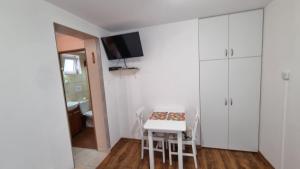 a small kitchen with a table and white cabinets at Bryza in Trzęsacz