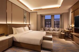 a bedroom with a large bed and a living room at Hilton Garden Inn Xuzhou Yunlong in Xuzhou