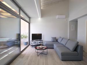 a living room with a couch and a tv at Perla al Mare in Adelianos Kampos