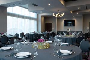 a conference room with tables and chairs with glasses at The Axis Moline Hotel, Tapestry Collection By Hilton in Moline