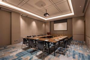 una sala conferenze con un lungo tavolo e sedie di Hilton Garden Inn Xuzhou Yunlong a Xuzhou
