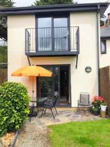 a patio with a table and an umbrella at Bryn Mynach Annex in Barmouth