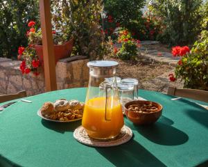 Arafo的住宿－Mountain Getaway for Hikers 2，一张桌子,上面放着一壶橙汁和一盘坚果
