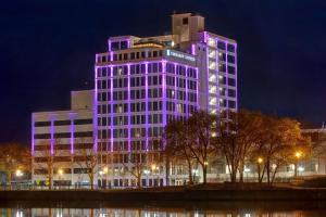 a building with purple lights on the side of it at Embassy Suites By Hilton Rockford Riverfront in Rockford