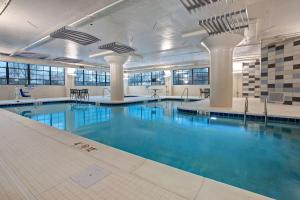 een groot zwembad met blauw water in een gebouw bij Embassy Suites By Hilton Rockford Riverfront in Rockford