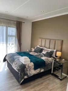 1 dormitorio con 1 cama y 1 mesa con lámpara en Spacious Apartment, en Johannesburgo