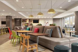 a lobby with a couch and tables and chairs at Home2 Suites By Hilton Glen Mills Chadds Ford in Glen Mills