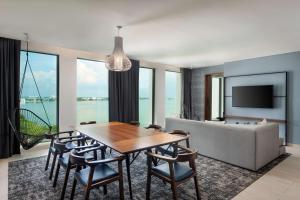 uma sala de jantar com uma mesa e cadeiras e um sofá em Canopy By Hilton Cancun La Isla em Cancún