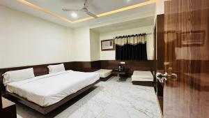 a bedroom with a bed and a table and a door at Hotel Varanasi Palace in Varanasi