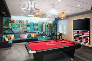 a living room with a pool table and a mural at Tru By Hilton Atlanta Northlake Parkway, Ga in Atlanta