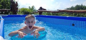 a young boy swimming in a swimming pool at Beauty Wood House in The Forest in Vîlcăneşti