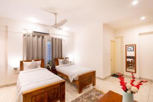 een slaapkamer met 2 bedden en een tafel bij The Silver Chimes Suites in Bangalore