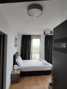 a bedroom with a white bed and a window at Marina Sarafovo in Burgas City