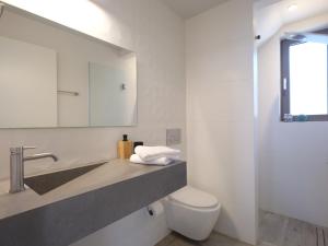 a bathroom with a sink and a toilet and a mirror at Perla al Mare in Adelianos Kampos +27 photos