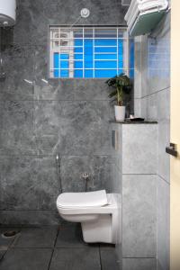 ein Bad mit einem WC und einem Fenster in der Unterkunft The Silver Chimes Suites in Bangalore