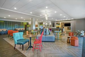 una sala de espera con mesas y sillas coloridas en Home2 Suites By Hilton Lawrenceville Atlanta Sugarloaf, Ga, en Lawrenceville