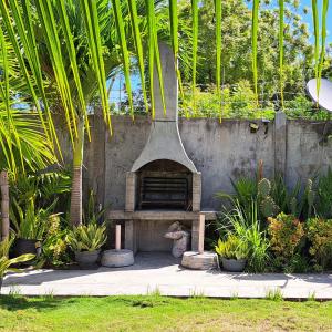 un forno in pietra in un giardino con piante di Mirka's Guest House a Isola di Bantayan