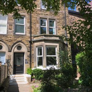 a brick house with a black door and windows at Comfy big 7 bedroom townhouse in Harrogate