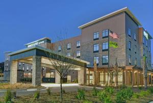 an exterior view of a hotel with an american flag at Home2 Suites By Hilton Charleston Daniel Island, Sc in Charleston