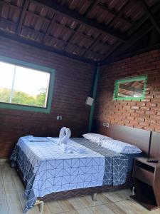 Zimmer mit einem Bett in einer Ziegelwand in der Unterkunft Sítio do pica pau amarelo in São Thomé das Letras