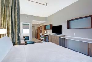 a hotel room with a bed and a flat screen tv at Home2 Suites By Hilton Charleston Daniel Island, Sc in Charleston