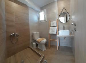 y baño con aseo, lavabo y espejo. en tsoukalaria studios, en Skopelos Town