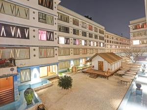 ein großes Apartmenthaus mit einem Innenhof mit einem kleinen Schuppen in der Unterkunft Townhouse Royal Palms Hotel - Daisy in Mumbai