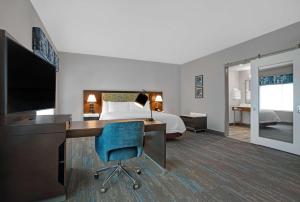a hotel room with a bed and a desk with a computer at Hampton Inn & Suites Farmers Branch Dallas, Tx in Farmers Branch