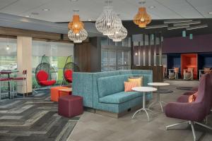 vestíbulo con sofá, sillas y mesas en Tru By Hilton Charlotte Airport Lake Pointe en Charlotte
