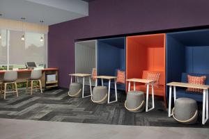 una oficina con mesas, sillas y paredes púrpuras en Tru By Hilton Charlotte Airport Lake Pointe en Charlotte