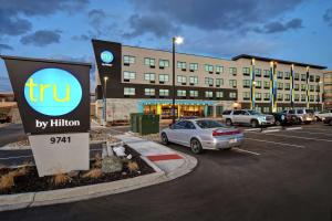 un cartel en un estacionamiento frente a un hotel en Tru By Hilton Denver South Park Meadows, Co, en Lone Tree