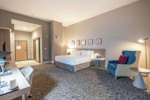 Habitación de hotel con cama y silla en Hilton Garden Inn Wichita Downtown, Ks en Wichita