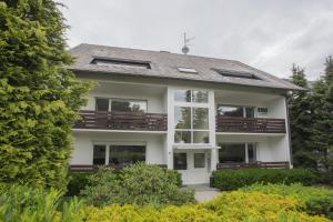 a large white house with a porch and balcony at Appartement Brink Fichtenweg 41 in Winterberg