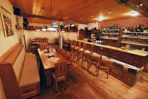 um restaurante com mesas e cadeiras de madeira e um bar em Hotel Vydrovy Boudy em Pec pod Sněžkou