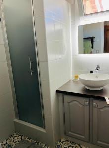 uma casa de banho com um lavatório e uma cabina de duche em vidro. em Villa Victoire 3 chambres em Venelles