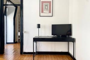 里斯本的住宿－Central Hidden Gem Rustic Modern 2 Bedroom Flat，房间里的一张黑桌上的电视