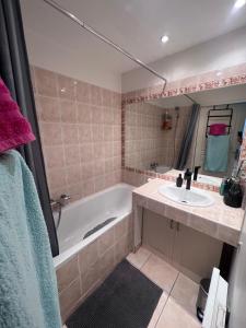 ein Badezimmer mit einer Badewanne und einem Waschbecken in der Unterkunft Appartement T2 avec jardin privé, piscine et barbecue in Lorgues