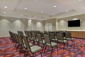 a row of chairs in a room with a flat screen tv at Home2 Suites By Hilton West Palm Beach Airport in West Palm Beach
