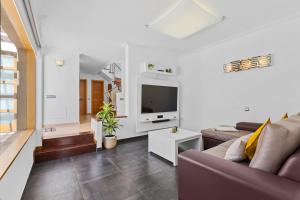a living room with a couch and a tv at Siesta Suites Lanzarote in Yaiza