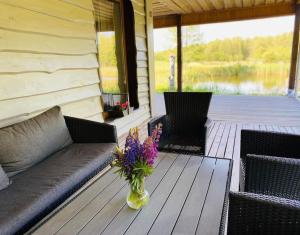 a vase of flowers sitting on a table on a porch at Forest springs. Family vacation tennis beach sauna in GratiÅ¡kÄ—s