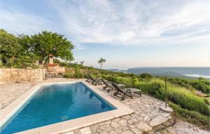 a swimming pool with benches next to a stone wall at Pet Friendly Home In Gora Glusic With House Sea View in Stanišovi
