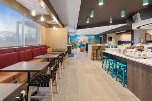 a restaurant with tables and chairs and a bar at Tru By Hilton Sharonville, OH in Cincinnati