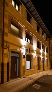 un bâtiment avec des lumières sur le côté dans l'établissement alojamiento cuatro estaciones, à La Pola de Gordón