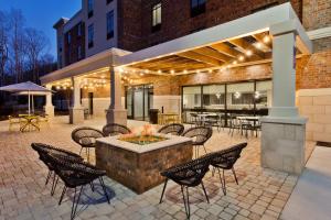 un patio con tavolo, sedie e un edificio di Home2 Suites By Hilton Alpharetta, Ga ad Alpharetta